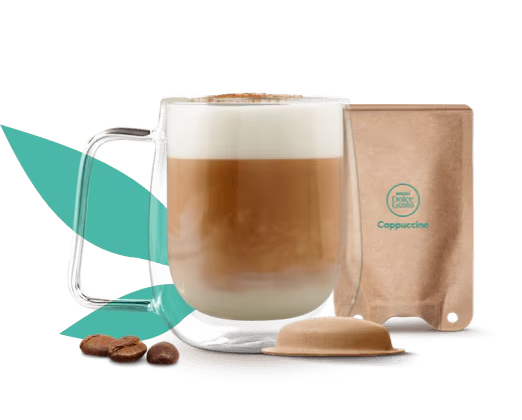 Caneca com cappuccino ao lado de uma cápsula e saqueta à base de papel