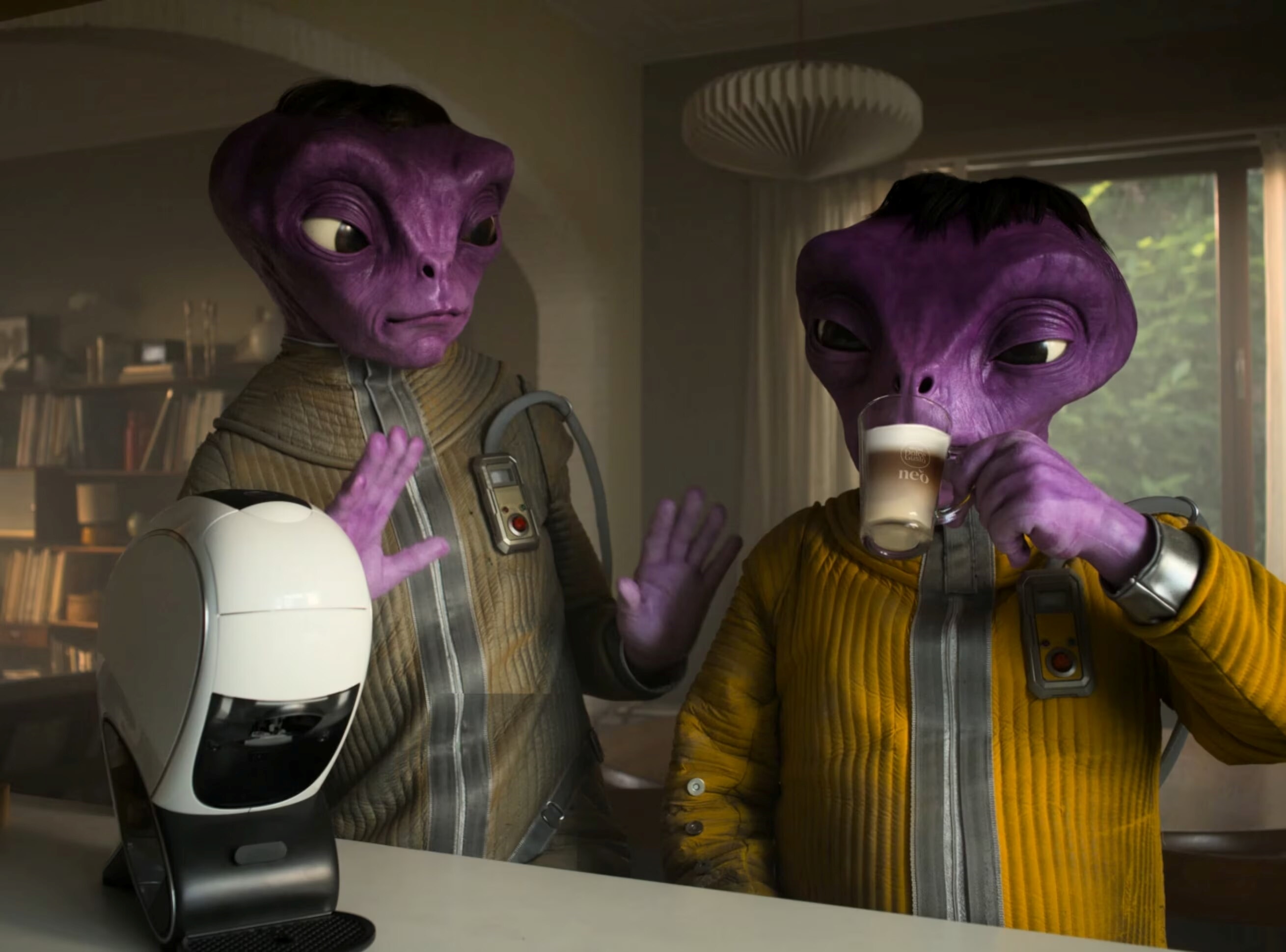 Miniatura de vídeo da campanha NEO Latte, com a máquina NEO Latte e duas figuras alienígenas.